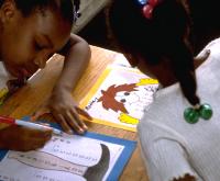 Elementary school African American girls adding long columns of big numbers